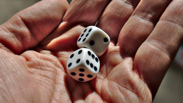 Why does dice rolling create cross-cultural gaming appeal?