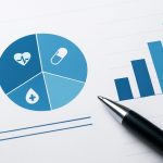 A pie chart with healthcare icons and a bar graph on a white surface next to a pen.